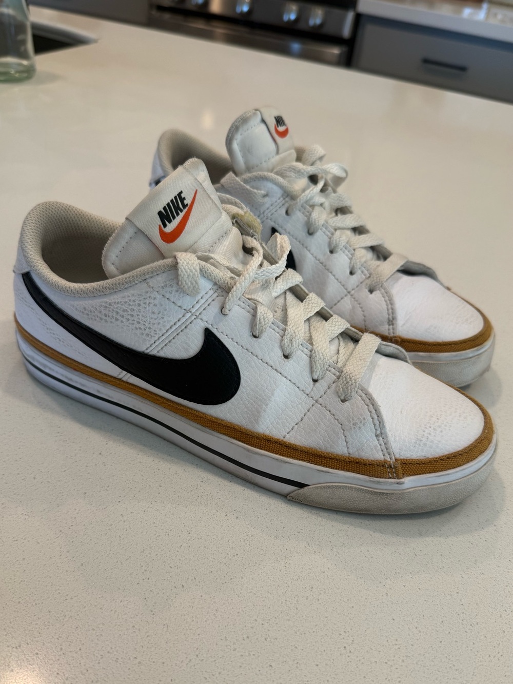 Nike White Low-Top Sneakers with Black Swoosh and Gold Accent